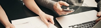 Image of people handling documents and a laptop