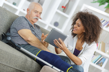 Carer using tech to help an injured person