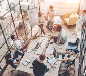 A team in an office communicating around a desk. 