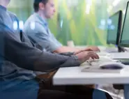 Person using a tablet and laptop to manage digital workflows