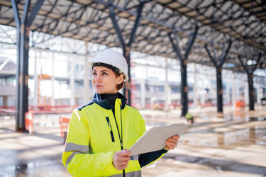 Female construction worker using construction software on site