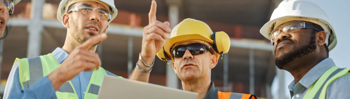 3 construction workers pointing towards something