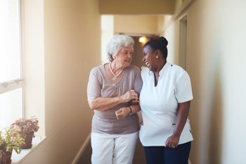 care worker and resident walking together