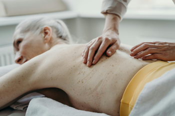 close-up of an elderly lady receiving a back massage