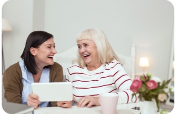 Two women smiling while talking to one another