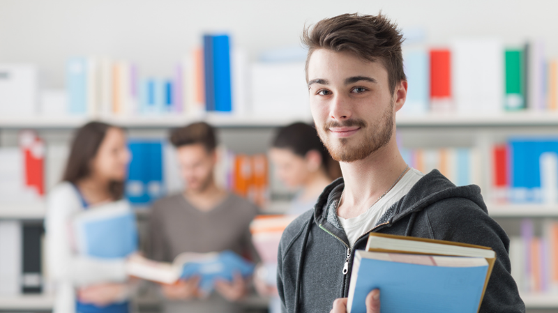 College student holding books in classroom