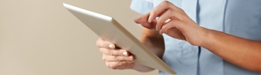 A nurse using a tablet device to check their virtual wards.