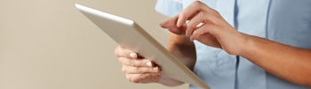 A nurse using a tablet device to check their virtual wards.