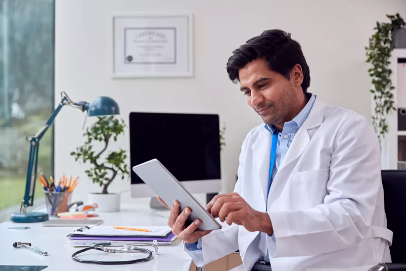 An image to show a doctor using an ipad to show how healthcare access is a determinant of health