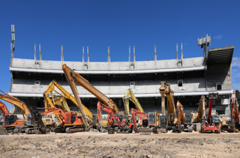 Two construction workers in front of diggers