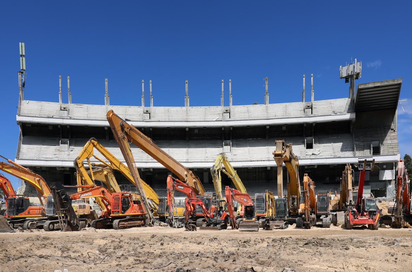 Enlarged Two construction workers in front of diggers