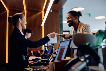 Hotel Reception Desk With Staff And Guest Interacting