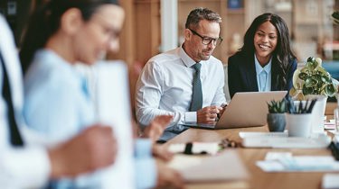 Office workers sitting down smiling 