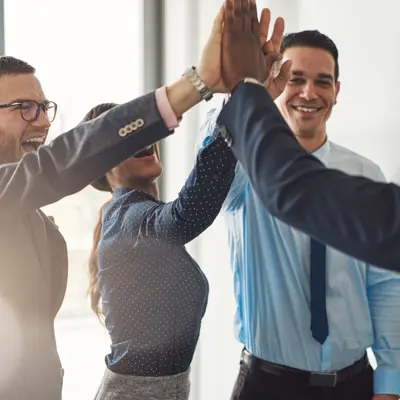 Team of legal professionals in a modern office raise a collective high-five beside a wall  symbolizing successful legal document collaboration