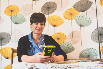 nurse on her iphone sitting at a table