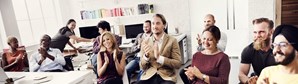 Image of happy employees clapping during an announcement at work
