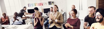 Image of happy employees clapping during an announcement at work