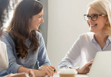 Two women smiling at eachother 
