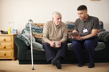 A social prescribing link worker with an older man discussing his wellbeing.
