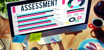 Desktop computer with school assessment results on display screen