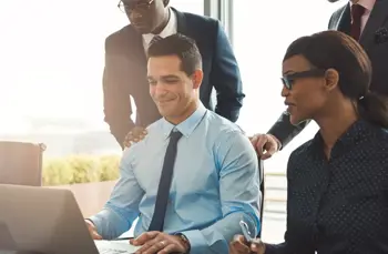 Team reviewing work on a laptop during a collaborative client experience session