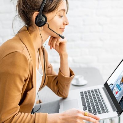 A woman with a headset on her computer 