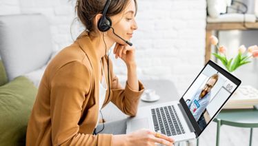 A woman with a headset on her computer 