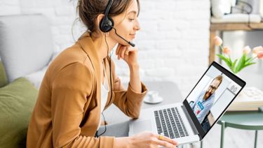 A woman with a headset on her computer