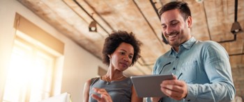 Two people talking one with a tablet