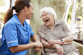 care worker and resident laughing and having a joyful conversation