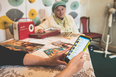 A lady on her phone and an elderly woman watching her