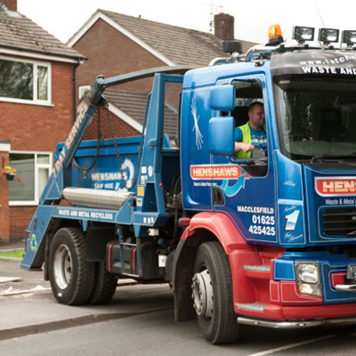 Henshaws skip truck parked outside house