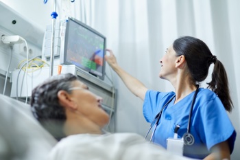 A clinician checking a patient's vital signs on a monitor.