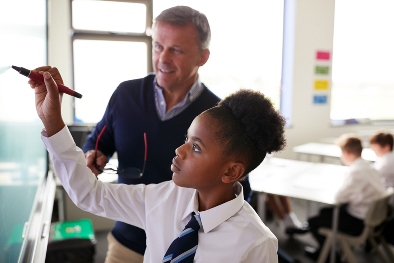Teacher supporting student at whiteboard