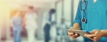 A nurse using a tablet to read electronic health records.