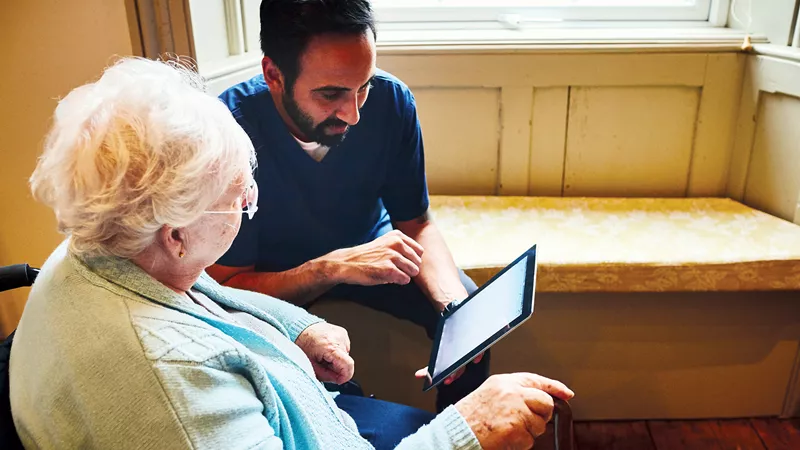 Carer reviewing reflective practice with elderly woman 