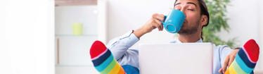 Image of relaxed office worker working from home and drinking coffee
