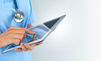A nurse using a tablet device to check patient data.