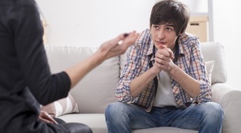 A young man talks with a clinician.