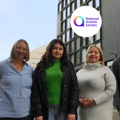 Three charity volunteer stood outside glass building