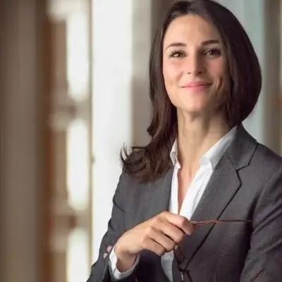 Professional individual in business attire holding glasses, shown as a client providing feedback on Access Legal software