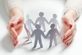 Close-up of a pair of hands cupped around paper people chain