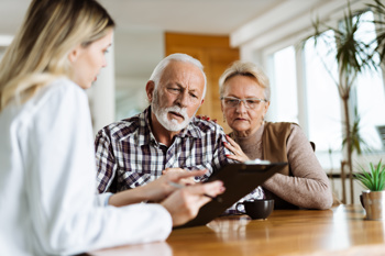 carer discussing the care plans with two elderly residents