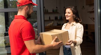 Woman getting a parcel from a delivery driver