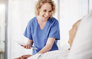A nurse laughing with an elderly patient 