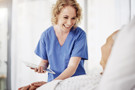 A nurse laughing with an elderly patient 