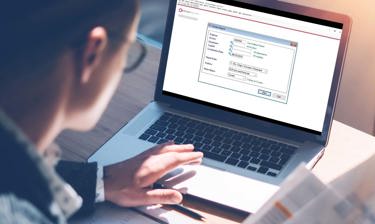 A man with glasses on his laptop