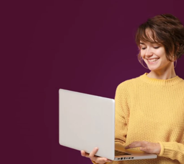 Lady smiling in yellow jumping holding laptop