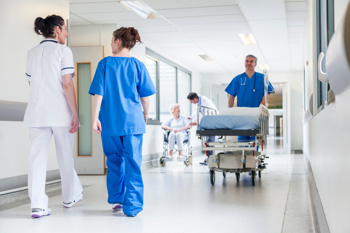 A hospital bed being moved from one ward to another.