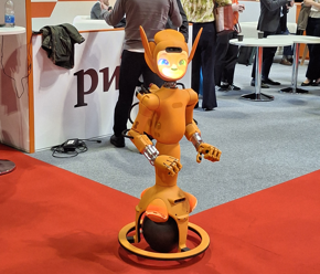 Orange mechanical robot with a bit smile at rewired 2026